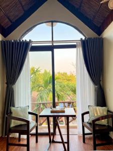 a dining room with a table and a large window at Tam Coc Sora - Traditional Home - Center in Vũ Lâm