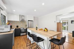 una cucina con un tavolo e sedie in una stanza di Annelise a Lorne Altre 4 foto