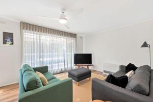 un soggiorno con due divani e una TV a schermo piatto di Annelise a Lorne