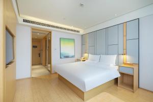 Ένα ή περισσότερα κρεβάτια σε δωμάτιο στο JI Hotel Shanghai Jiuting Center