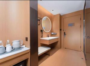 een badkamer met een wastafel en een spiegel bij JI Hotel Suzhou Dushu Lake Ecological Park in Suzhou +23 foto's