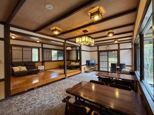 een grote kamer met houten tafels en een bank bij Fuji-Kurohime- in Shinano