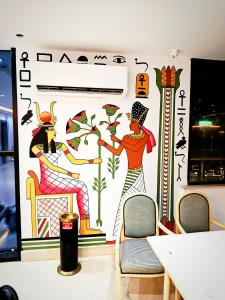 een muur met een muurschildering van twee vrouwen erop bij Pyrs Giza Heaven in Caïro