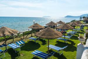 a group of chairs and umbrellas and the ocean at Holiday Village in Fondi