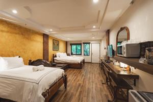 Namtok Sarika Resotel في ناخون نايوك: غرفة فندقية بسريرين وتلفزيون