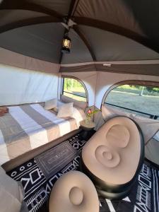 a room with a bed and chairs in a tent at Samatha Camper in Chiang Dao