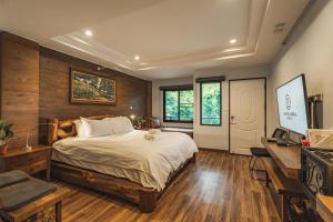 Namtok Sarika Resotel في ناخون نايوك: غرفة نوم بسرير ومكتب ونوافذ