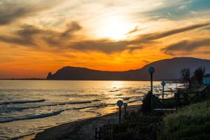 a sunset on the beach with the sun setting at Holiday Village in Fondi