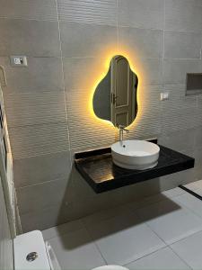 Un baño con un lavabo y un espejo en la pared. en Almajidy Villa, en El Cairo