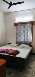 a bed in a room with a ceiling fan at Shevaroyen villa yercaud in Yercaud