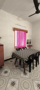 a room with a table and chairs and a window at Shevaroyen villa yercaud in Yercaud +4 photos