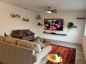a living room with two couches and a flat screen tv at The Orchid house !! Your home away from home Gateway to Yosemite & UC Merced this for a Room in Merced