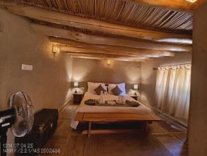 Saspul GömpaMoljoks Heritage House的卧室里有一张大床，配有木质天花板