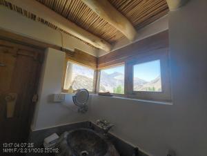 Saspul GömpaMoljoks Heritage House的一间带镜子和窗户的盥洗盆的浴室