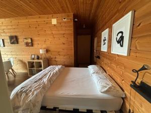 a bed in a room with a wooden wall at Arbegain Etxea in Aizarna