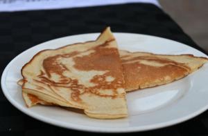 two pancakes on a white plate on a table at Oloiba Nkuti Lodge in Masai Mara +28 photos
