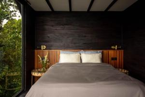 a bedroom with a large bed with a wooden wall at Wanagiri Cabin in Gitgit