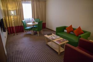 un soggiorno con divano verde e tavolo di Saffron Boutique Hotel a Dubai
