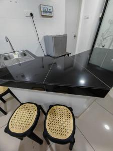 a glass desk with two chairs in front of it at Suite U Studio 108 in Kota Bharu