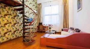 a living room with a couch and a spiral staircase at GreenTree Inn Jiangsu Wuxi Meiyuan Kaiyuan Temple Subway Master Station Express Hotel in Wuxi +132 photos