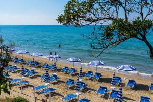 a group of chairs and umbrellas on a beach at Holiday Village in Fondi