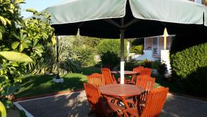 a wooden table and chairs under an umbrella at Elisabeth Villas in Kerveli