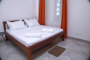 a bed with two white towels on top of it at Zuri Homes 6 B in Mombasa