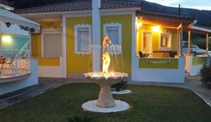 a fountain in a yard in front of a house at Elisabeth Villas in Kerveli