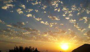 a sunset with clouds in the sky at Elisabeth Villas in Kerveli