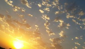a sunset with clouds in the sky at Elisabeth Villas in Kerveli