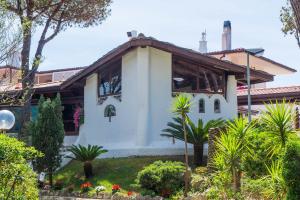 a white building with a church with plants and trees at Holiday Village in Fondi