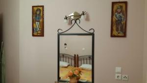 a mirror on a wall next to a bed at Elisabeth Villas in Kerveli