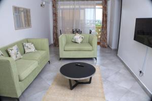 a living room with two green chairs and a table at Zuri Homes 6 B in Mombasa