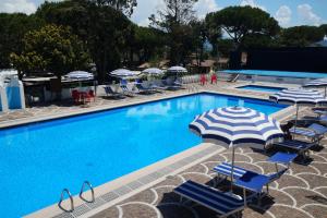a swimming pool with chairs and an umbrella at Holiday Village in Fondi