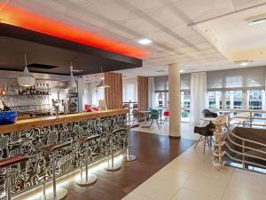 un restaurante con bar y zona de comedor en ibis Epernay Centre Ville, en Épernay
