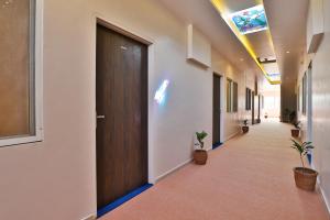 un pasillo de oficina con puerta y macetas en Hotel O Milan Party Hall, en Vadodara