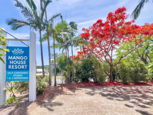 a sign for mana house resort with trees and flowers at Tropic Drift in Airlie Beach