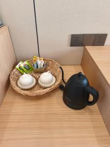 a tea kettle and a basket on a table at T&T Bungalow in Ban Khouaphan