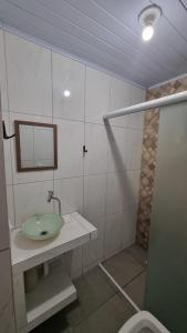 a bathroom with a sink and a mirror and a shower at Sobradinho Riviera, 3 Quadras do Mar - COM AR CONDICIONADO no quarto in Matinhos