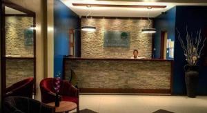 a woman is standing behind a counter in a salon at Victoria Palms Hotel in The Domain