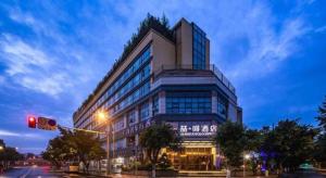 un edificio en una calle de la ciudad con un semáforo en James Joyce Coffetel Chengdu Jichang Road Shenxianshu, en Chengdú