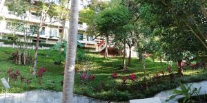 a garden in front of a building with trees and flowers at Baan-kawkaew-kata in Ban Karon