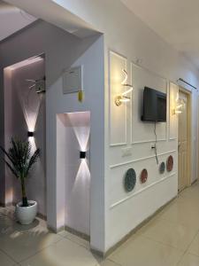 Stylish Comfort in the Heart of Dream Homes في غازي آباد: غرفة معيشة مع تلفزيون ونبات الفخار