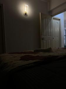 a bedroom with a bed and a light on the wall at Stylish Comfort in the Heart of Dream Homes in Ghaziabad