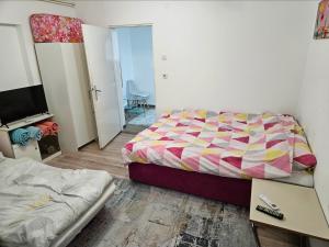 a bedroom with a bed and a desk and a tv at Apartman u centru Prnjavor in Prnjavor +5 photos