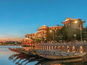 a row of boats in the water in front of a building at Chonpines Hotel North Xiamen Station Jimei University in Xiamen