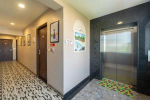 a hallway with a glass door and a tile floor at Treebo Premium Nova Candolim in Candolim +50 photos