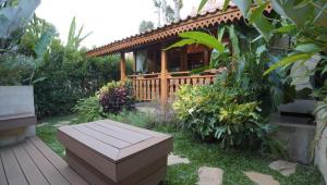 a wooden deck with a bench in a garden at Karenina Agung Resort Semarang in Gunungpati
