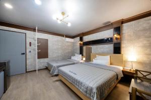 Gunsan Yes的一间带两张床和吊扇的卧室