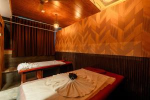 a room with two beds and two tables in it at Treebo Premium Nova Candolim in Candolim